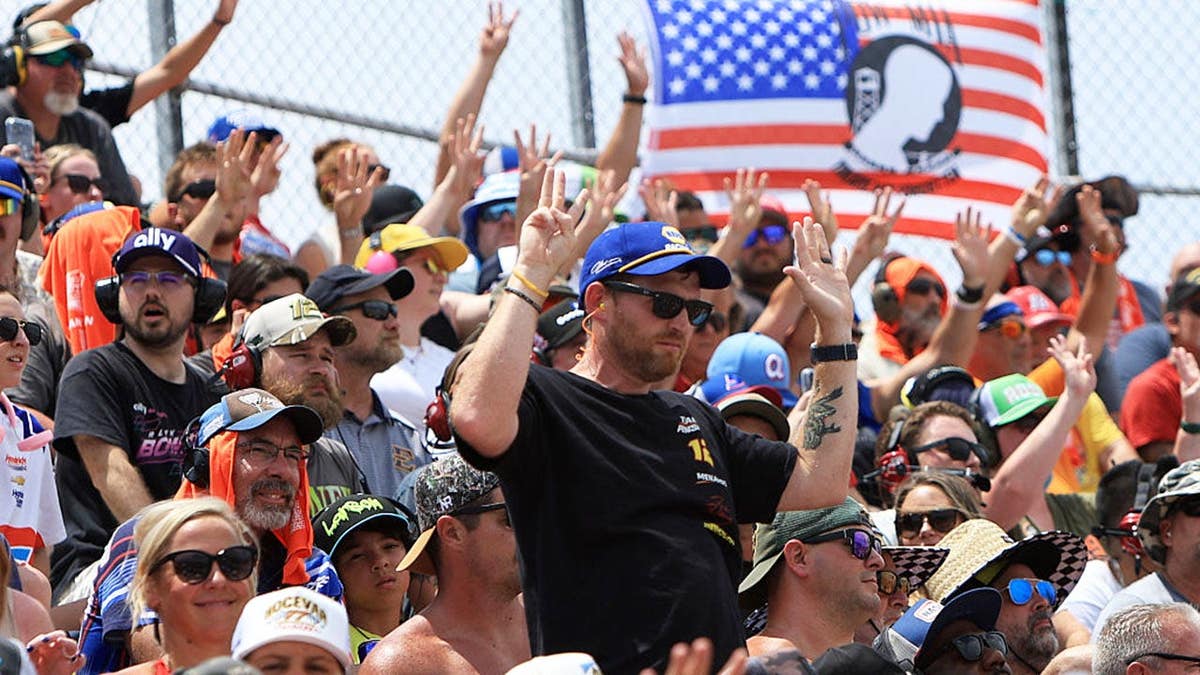 Race fans hold up eight fingers at North Wilkesboro Speedway.