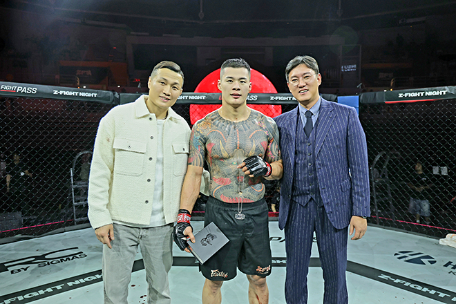 Contender Series Hwang In-soo is taking a photo to commemorate the victory of the Z-Fight Night 04 main event at the Seoul Olympic Handball Stadium in May 2026. On the left is Jung Chan-sung, CEO of ZFN, a two-time "Korean Zombie" in the UFC title battle, and on the right is So Jong-geun, chairman of Saegang Hospital's new instructor and supporters' association. Photo = MCPECC