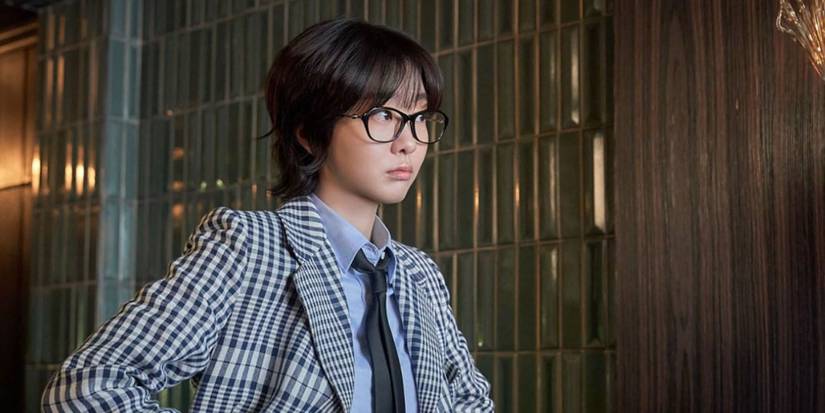 Kim Da-mi as Yoon E-na wearing glasses and a blazer in Nine Puzzles.