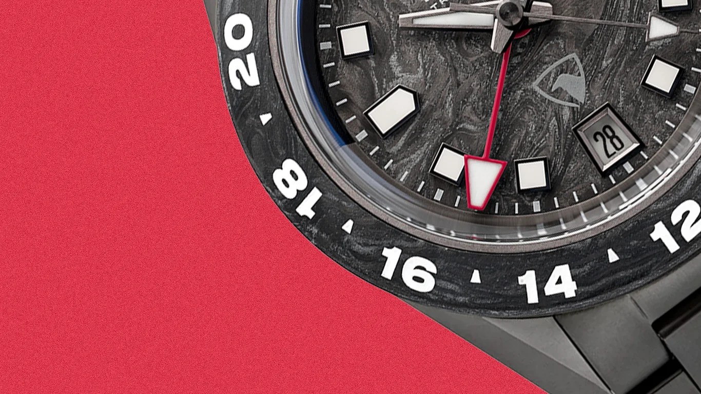 Close-up of a black watch face with white hour markers, a red-tipped second hand, and a date window showing