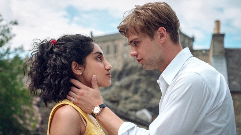 Dexter standing across from Emmy with his hand on the side of her neck in One Day