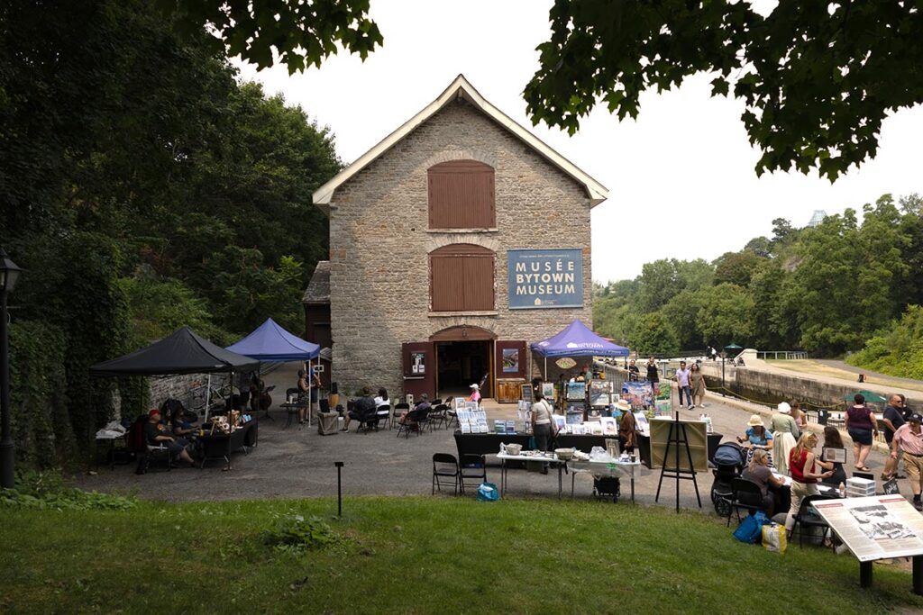 Vendor booths and patrons outside of the Bytown Museum in Ottawa, Ontario.