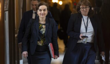 Quebec Premier Christine Fréchette walks along a National Assembly hallway with people behind her.