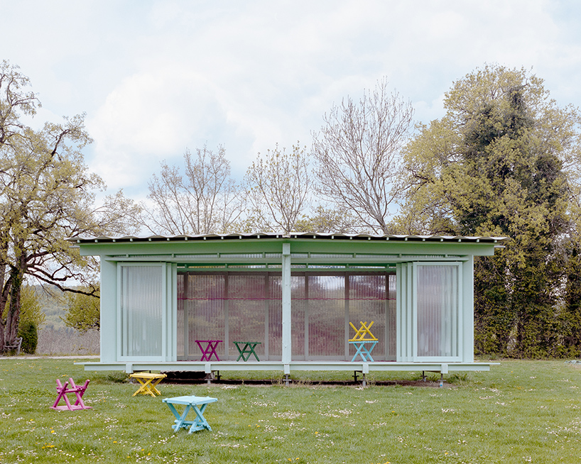 sliding timber frames and reused materials shape reversible pavilion within swiss meadow - 2