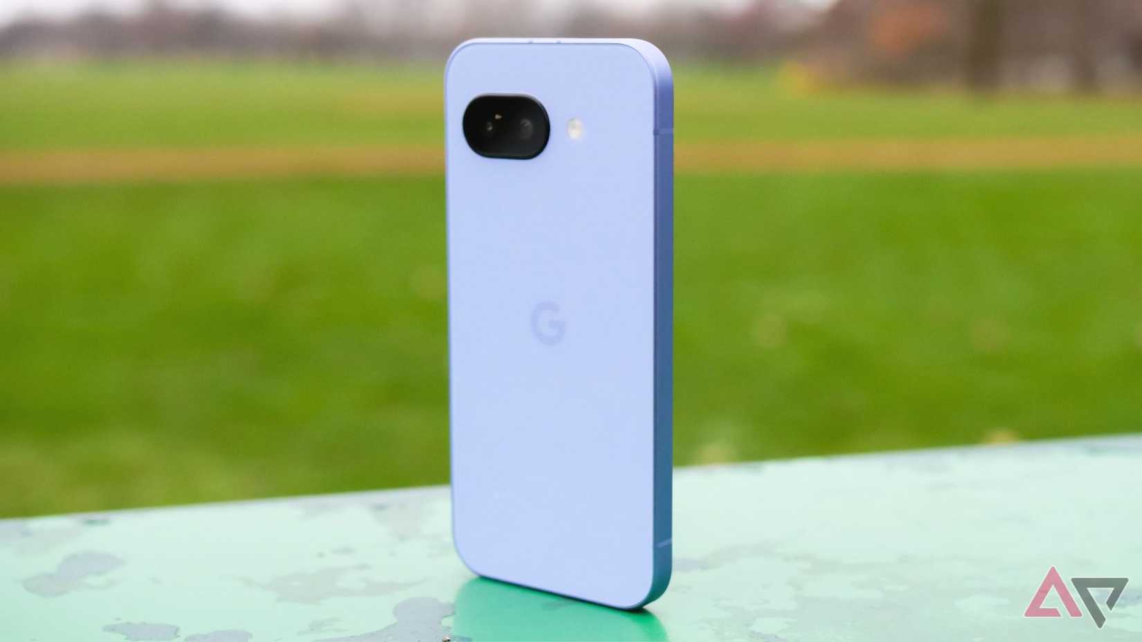 Pixel 9a standing upright on a park bench, with the purple back showing towards the camera