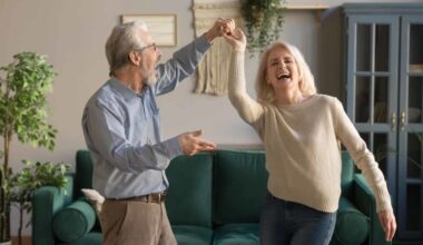 An older couple dance in their living room as they enjoy their retirement funded by ASX dividends