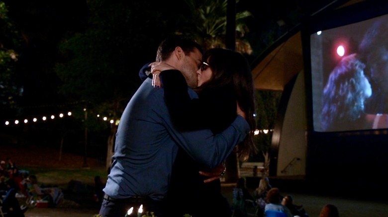 Nick and Jess kissing by an outdoor movie screening