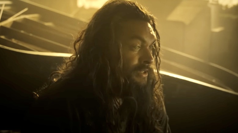 Baba Voss (Jason Momoa) standing in a dark room on 