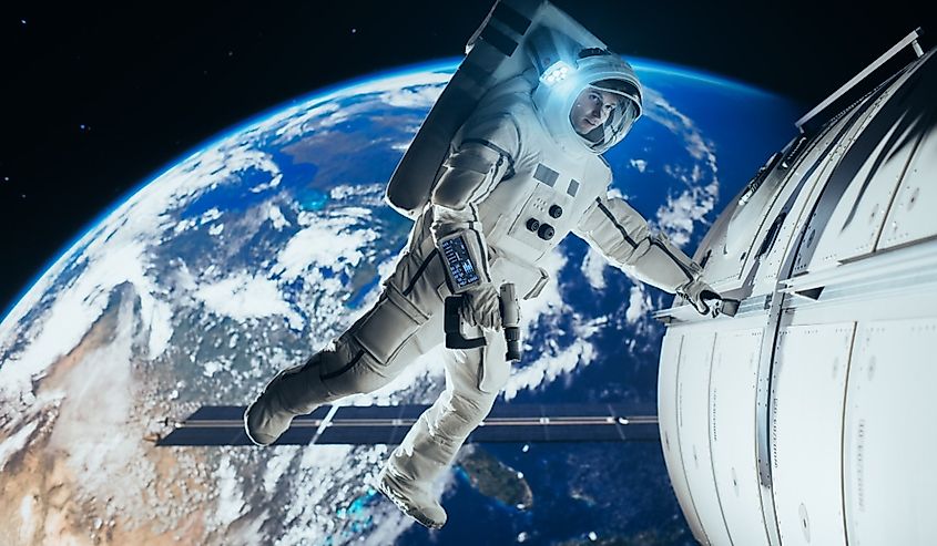 Astronaut Conducting Spacewalk Near International Space Station with Earth in Background.