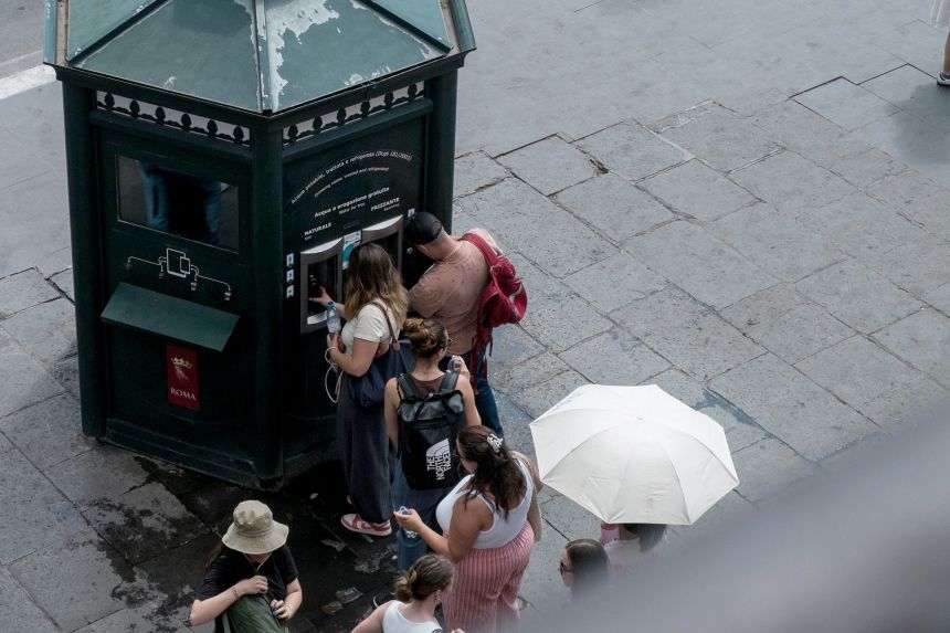 People line up to refill their water bottles at a public water dispenser near the Colosseum in Rome on July 4.