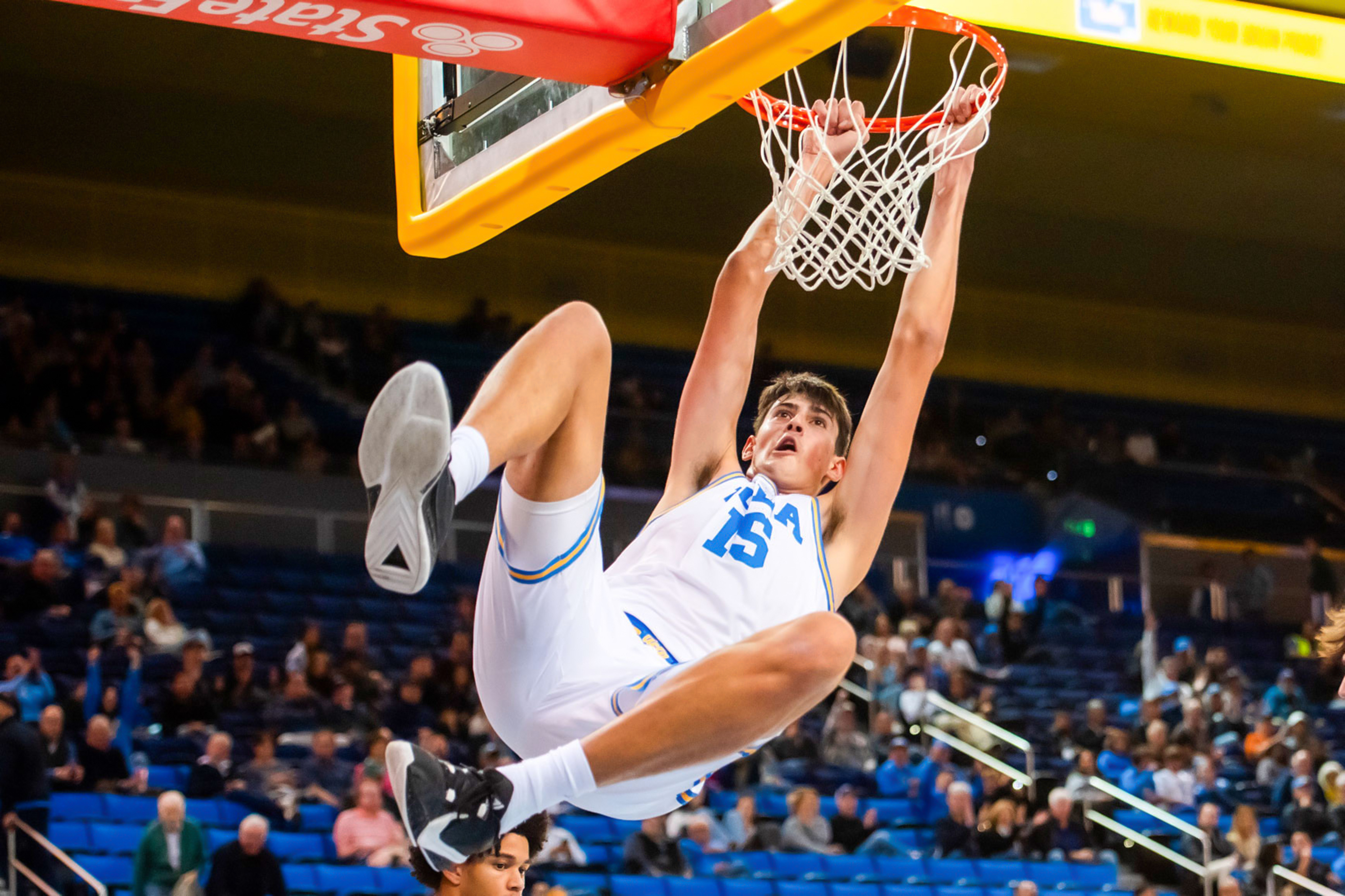 Former UCLA center Aday Mara hangs on the rim. Mara was the 12th overall pick in the 2026 NBA Draft, to the Oklahoma City Thunder. (Brianna Carlson/Daily Bruin staff)