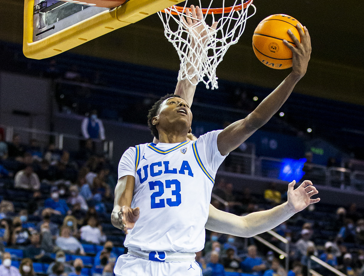 Former UCLA guard/forward Peyton Watson attempts a reverse layup past an opposing defender. Watson is currently an unsigned restricted free agent for the Denver Nuggets. (Daily Bruin file photo)