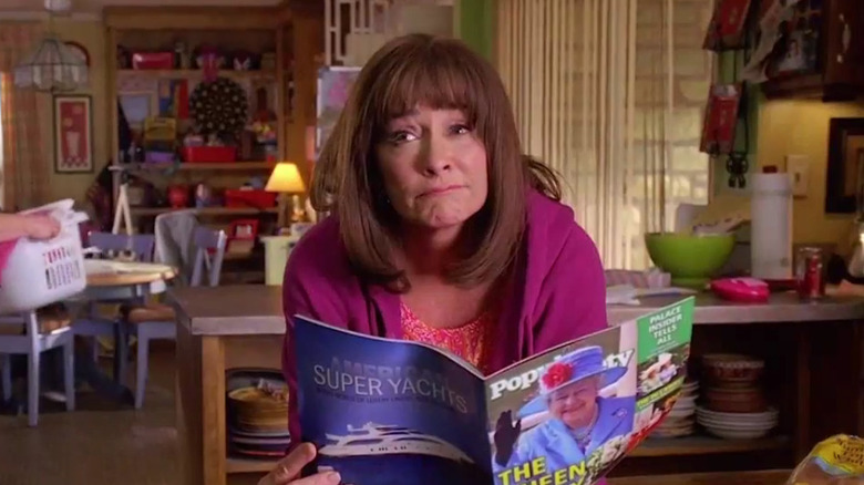 Frankie reading a magazine and leaning over a counter