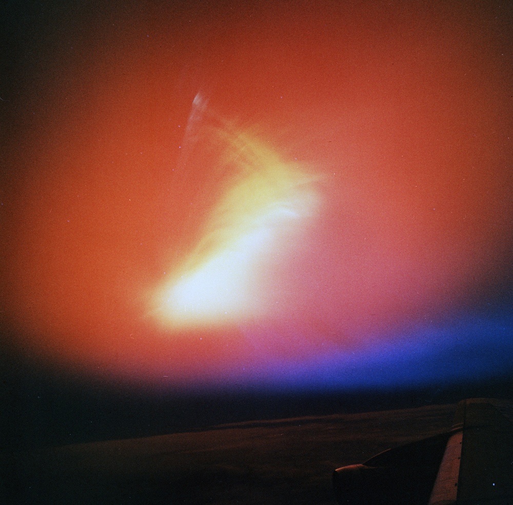 a yellow cloud high above the earth in the sky