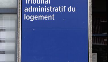 Sign for Tribunal office on building wall outside.