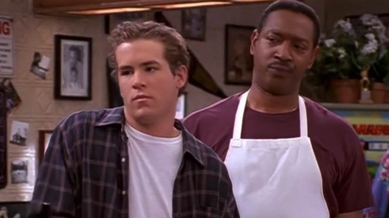 Berg (Ryan Reynolds) and Bill (Julius Carry) stand unamused in a pizza parlor in Two Guys and a Girl