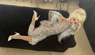 Katya Zamolodchikova reclining on a couch in a silver dress
