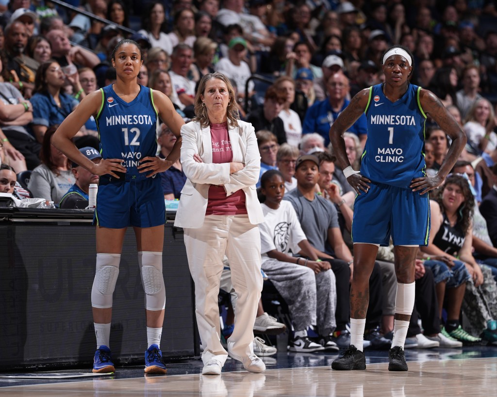 Two basketball players and a coach from the Minnesota Lynx standing on the court.