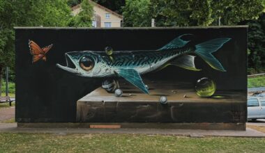 a horizontal mural of a fish floating above a table or surface with small bubble beneath it and an orange butterfly near its mouth