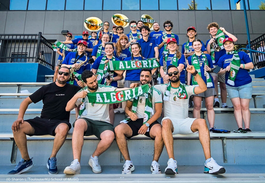 Members of the University of Kansas band holding banners for team Algeria (© Sharon L. Toulouse/KU School of Music)
