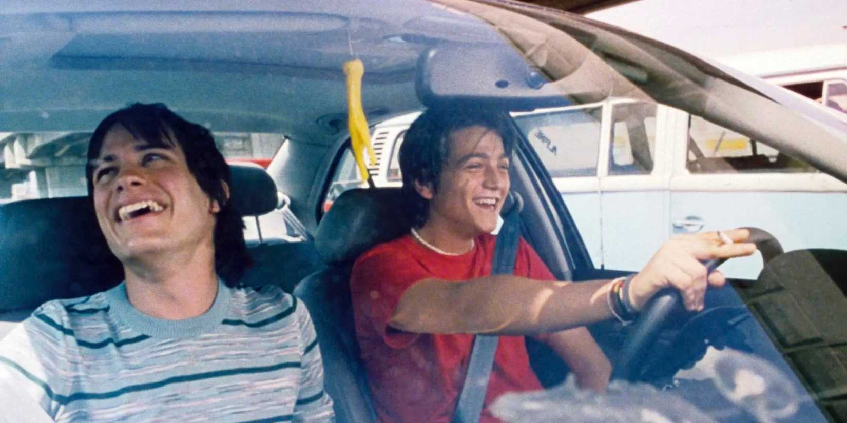Gael García Bernal as Julio and Diego Luna as Tenoch laughing while driving around in Y Tu Mamá También