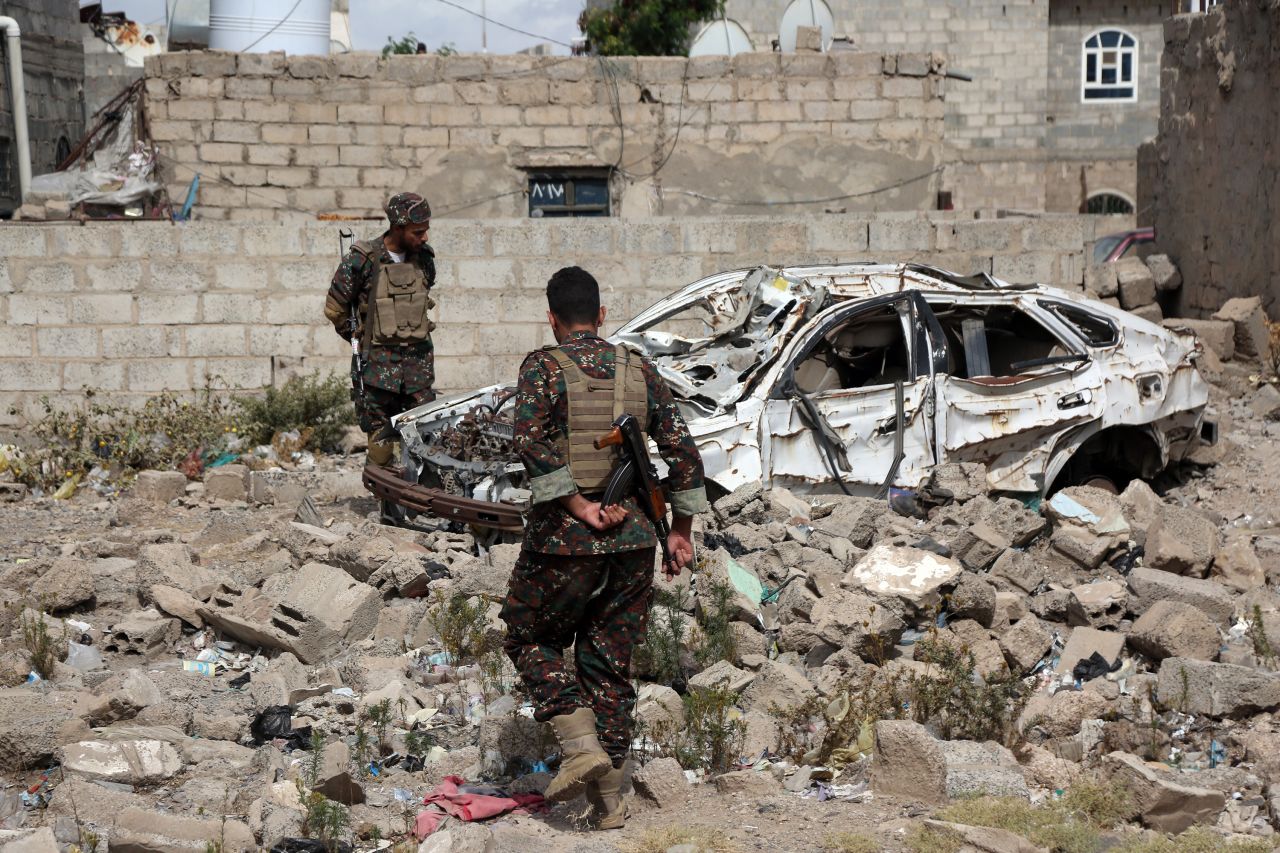 Members of Houthi security forces inspect a destroyed car, which was hit during airstrikes in Sana'a, Yemen, on March 26.