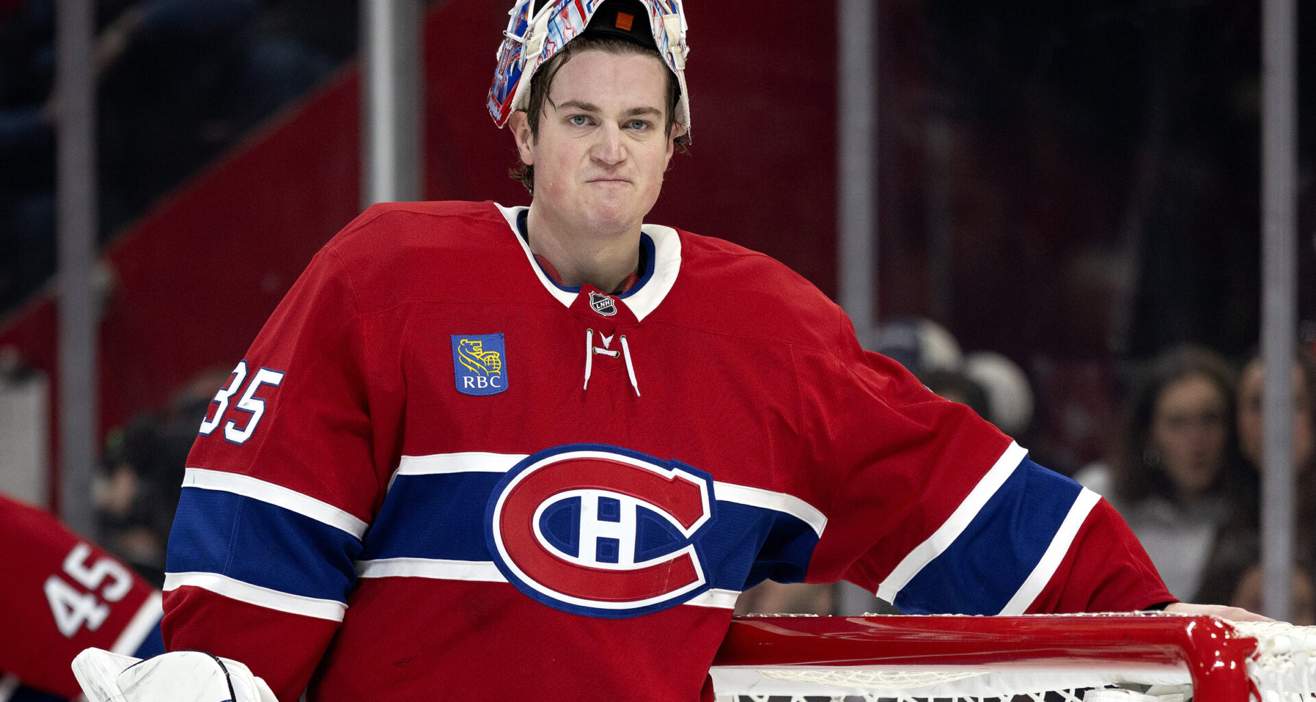 Samuel Montembeault stands in front of his net with his mask up and an unhappy look on his face.