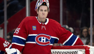Samuel Montembeault stands in front of his net with his mask up and an unhappy look on his face.