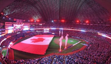 Apr 8, 2024; Toronto, Ontario, CAN;  The Canadian flag is unfurled during the anthems as the Toronto Blue Jays play their home opener against the Seattle Mariners at Rogers Centre. Mandatory Credit: Dan Hamilton-USA TODAY Sports