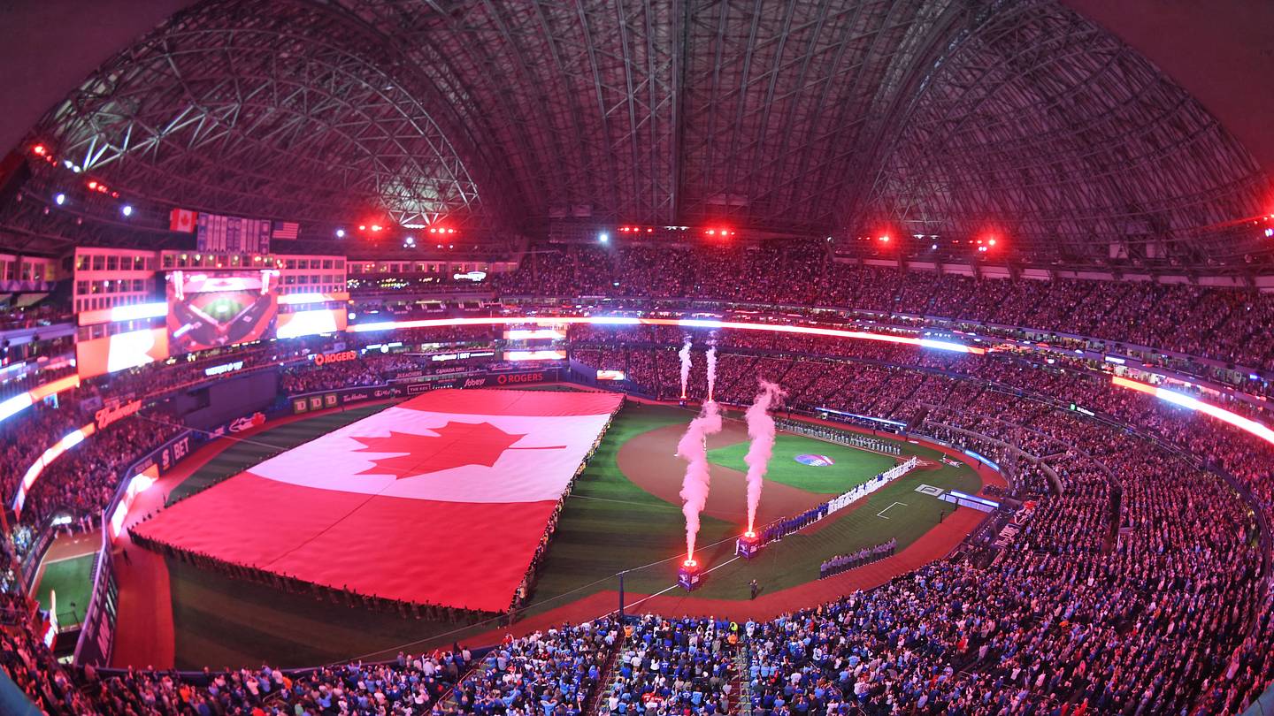 Apr 8, 2024; Toronto, Ontario, CAN;  The Canadian flag is unfurled during the anthems as the Toronto Blue Jays play their home opener against the Seattle Mariners at Rogers Centre. Mandatory Credit: Dan Hamilton-USA TODAY Sports