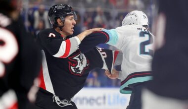 Mar 28, 2026; Buffalo, New York, USA;  Buffalo Sabres defenseman Logan Stanley (64) and Seattle Kraken defenseman Jamie Oleksiak (24) fight during the second period at KeyBank Center. Mandatory Credit: Timothy T. Ludwig-Imagn Images