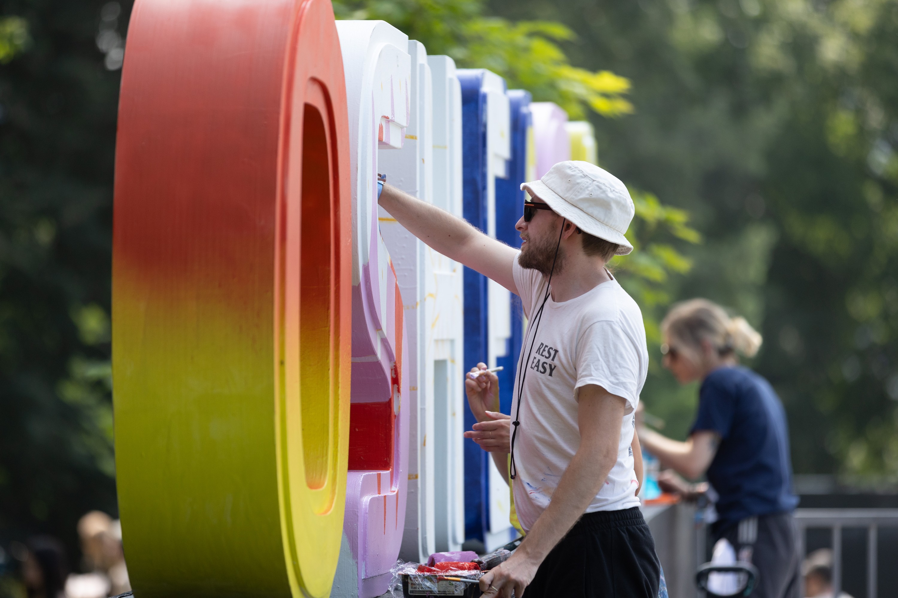 Artist Florian Semprez paints a block letter of the Osheaga sign at the Osheaga Music and Arts Festival
