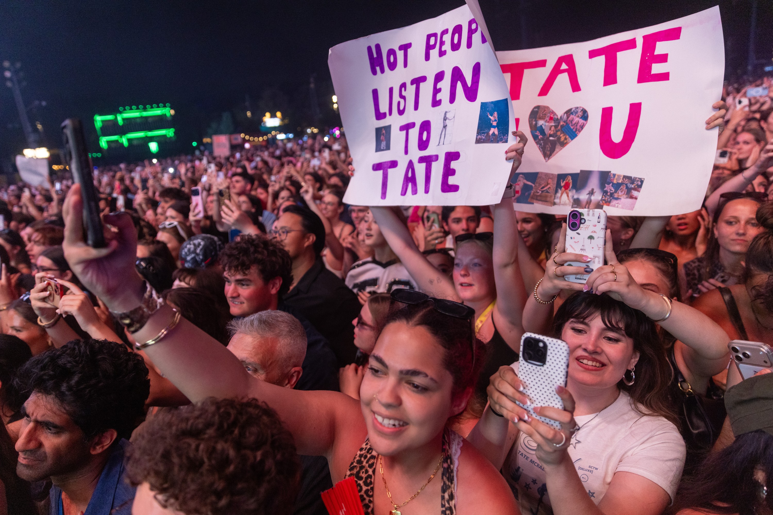 Tate McRae fans sing along to her set at the Osheaga Music and Arts Festival while holding up signs with messages like Hot People Listen to Tate