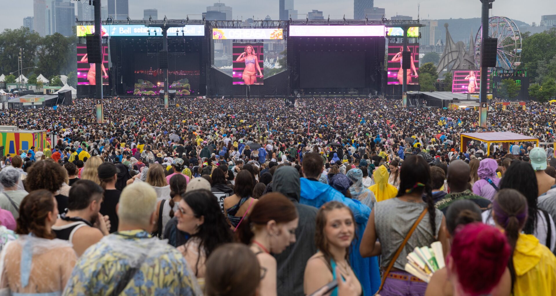 A large crowd on an overcast day at Osheaga, as seen from the back of the main site