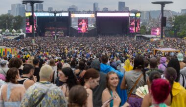 A large crowd on an overcast day at Osheaga, as seen from the back of the main site