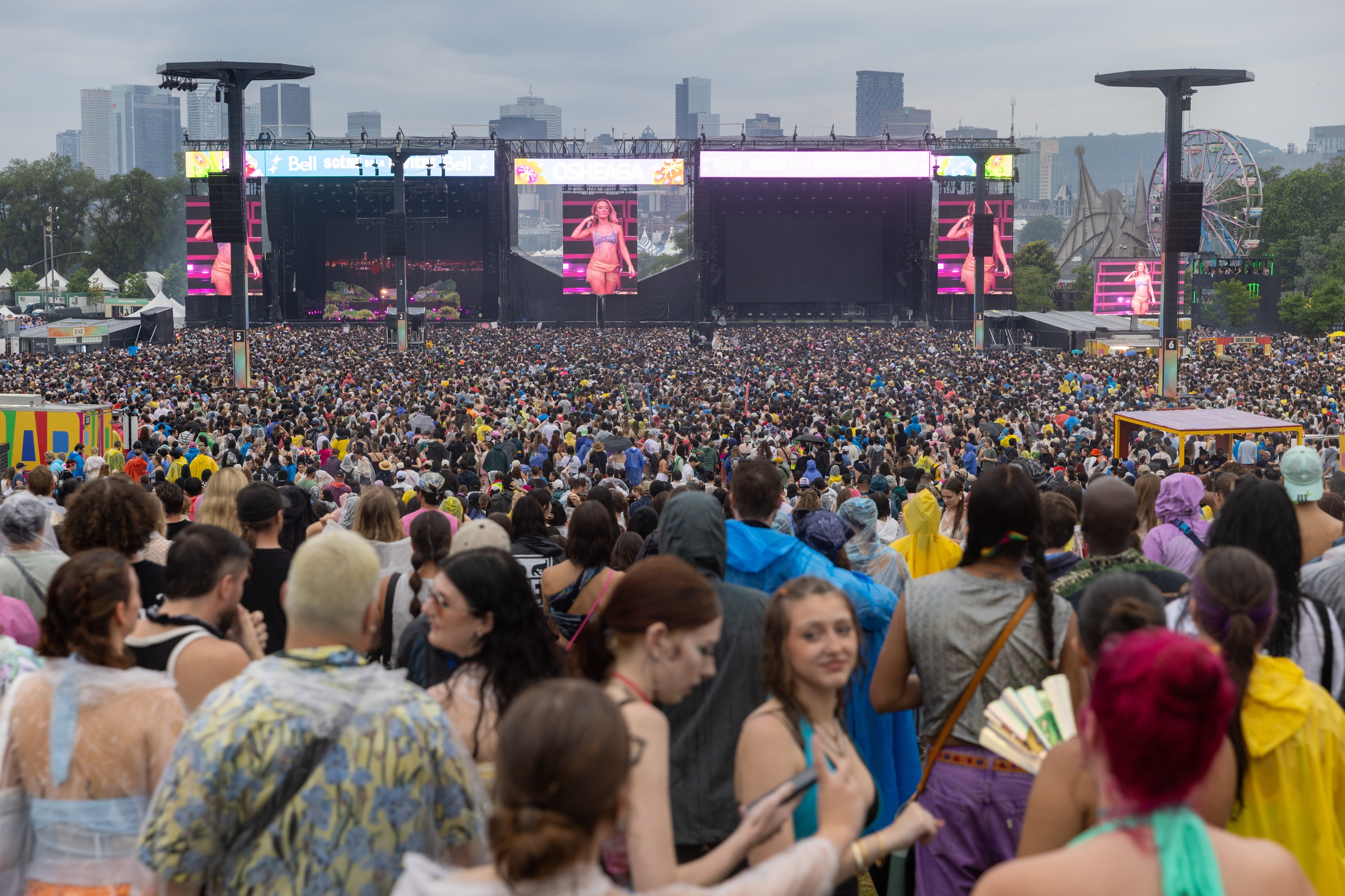 A large crowd on an overcast day at Osheaga, as seen from the back of the main site