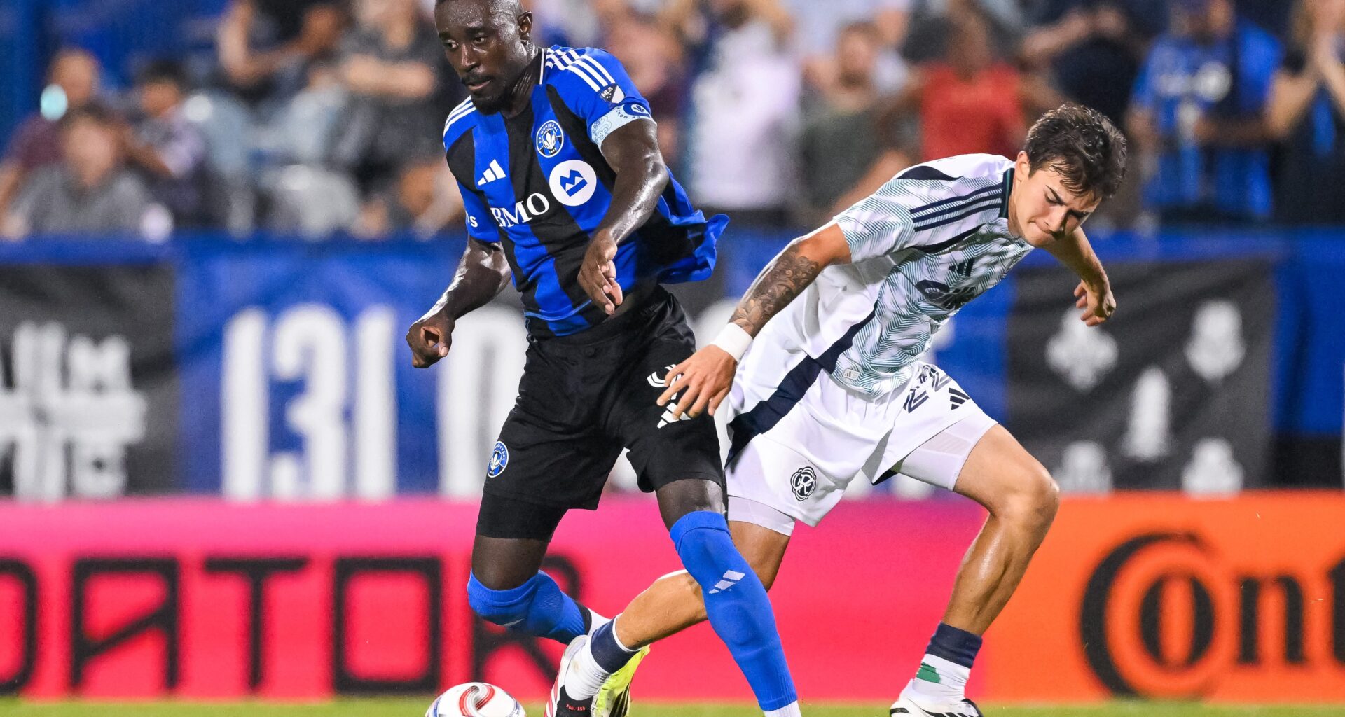 Prince Owusu of CF Montréal controls the ball against Ethan Kohler of the New England Revolution