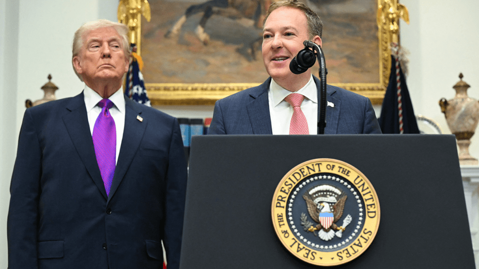 Two men, Donald Trump, and Lee Zeldin stand behind a podium with the US seal.