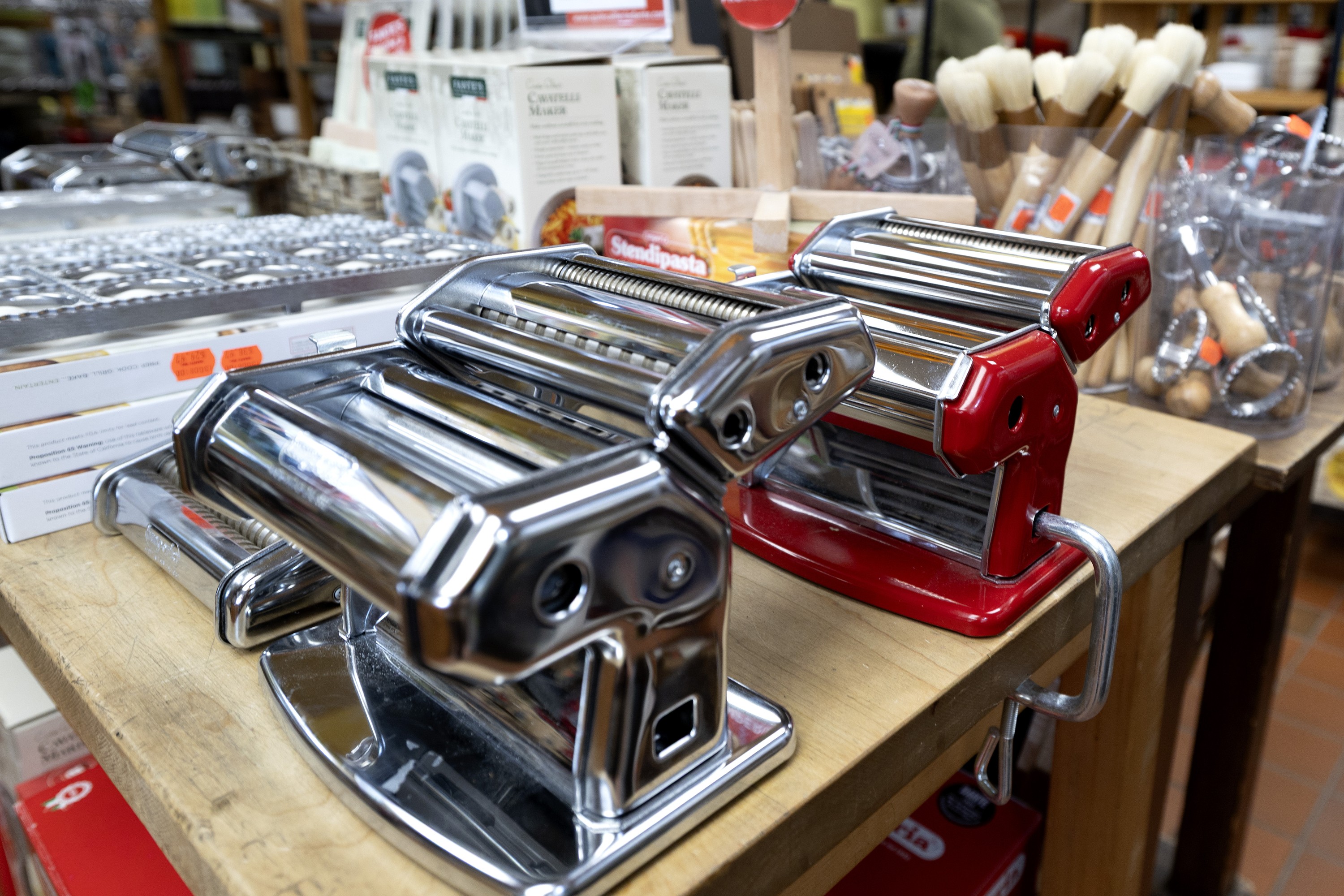 Two pasta machines, one stainless steel, one red-coloured, at Quincaillerie Dante.