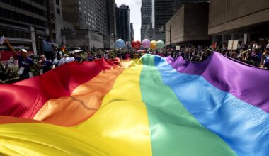 Participants in the 2026 Montreal Pride parade carry a large rainbow banner down Réné-Lévesque Boulevard