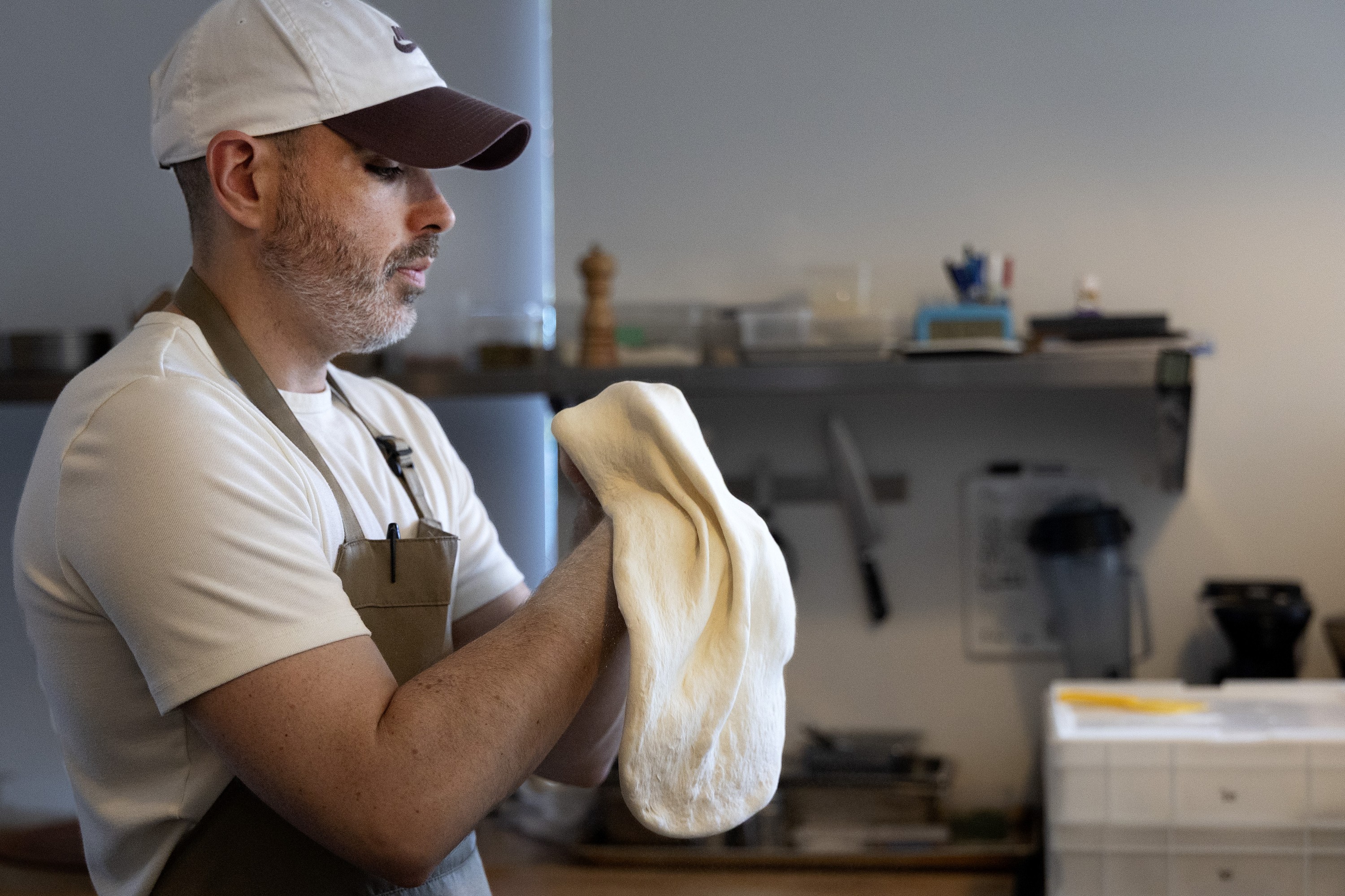 David Reilly working the pizza dough in his hands at Maps.