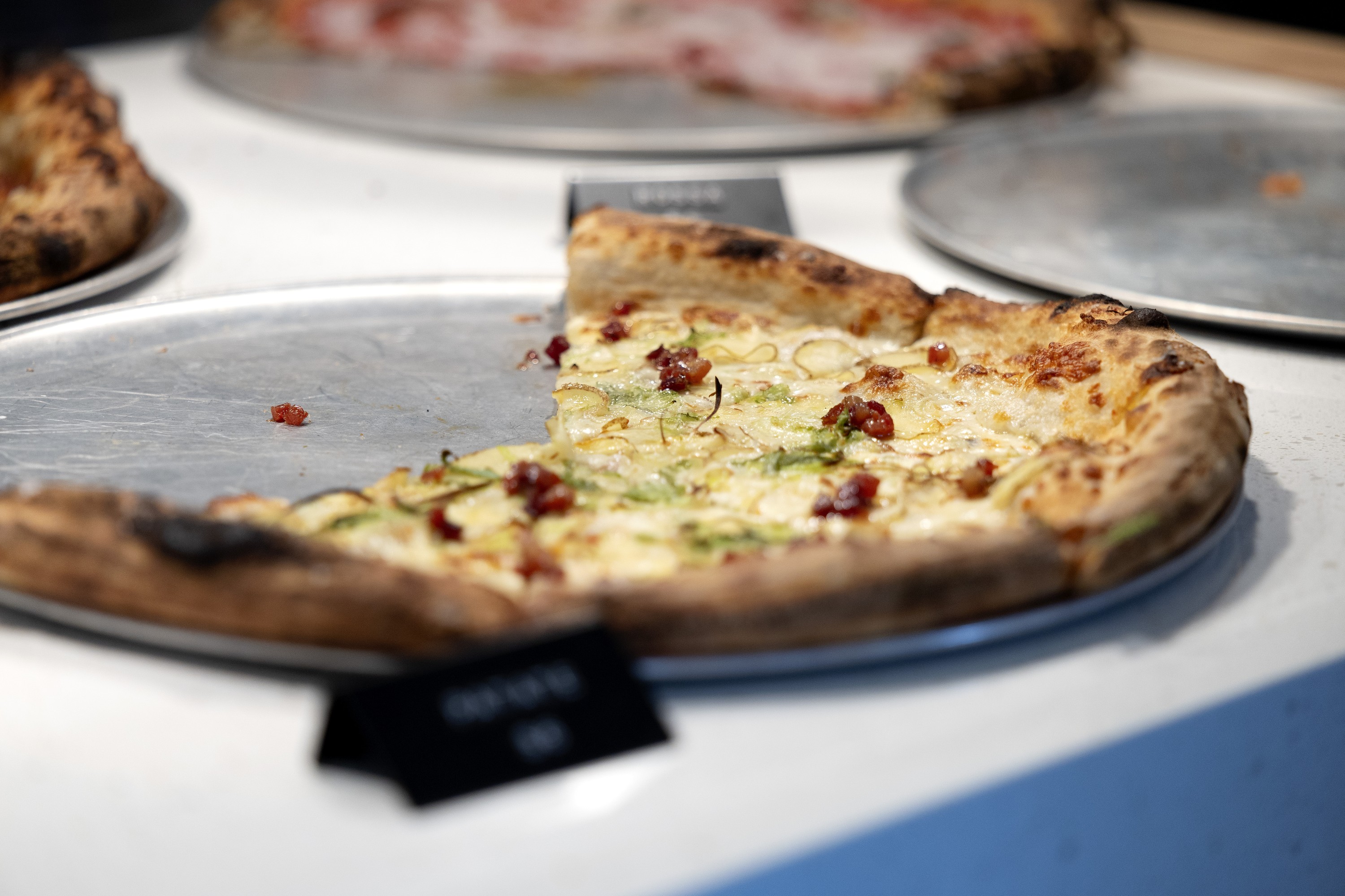 A potato pizza at Crosta with several slices missing.