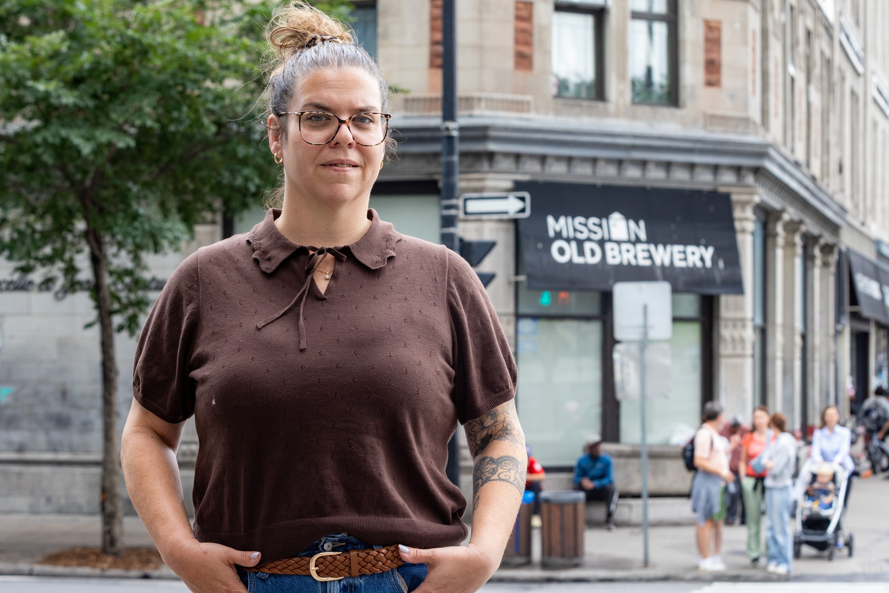 Woman stands outside building with Mission Old Brewery sign on it.