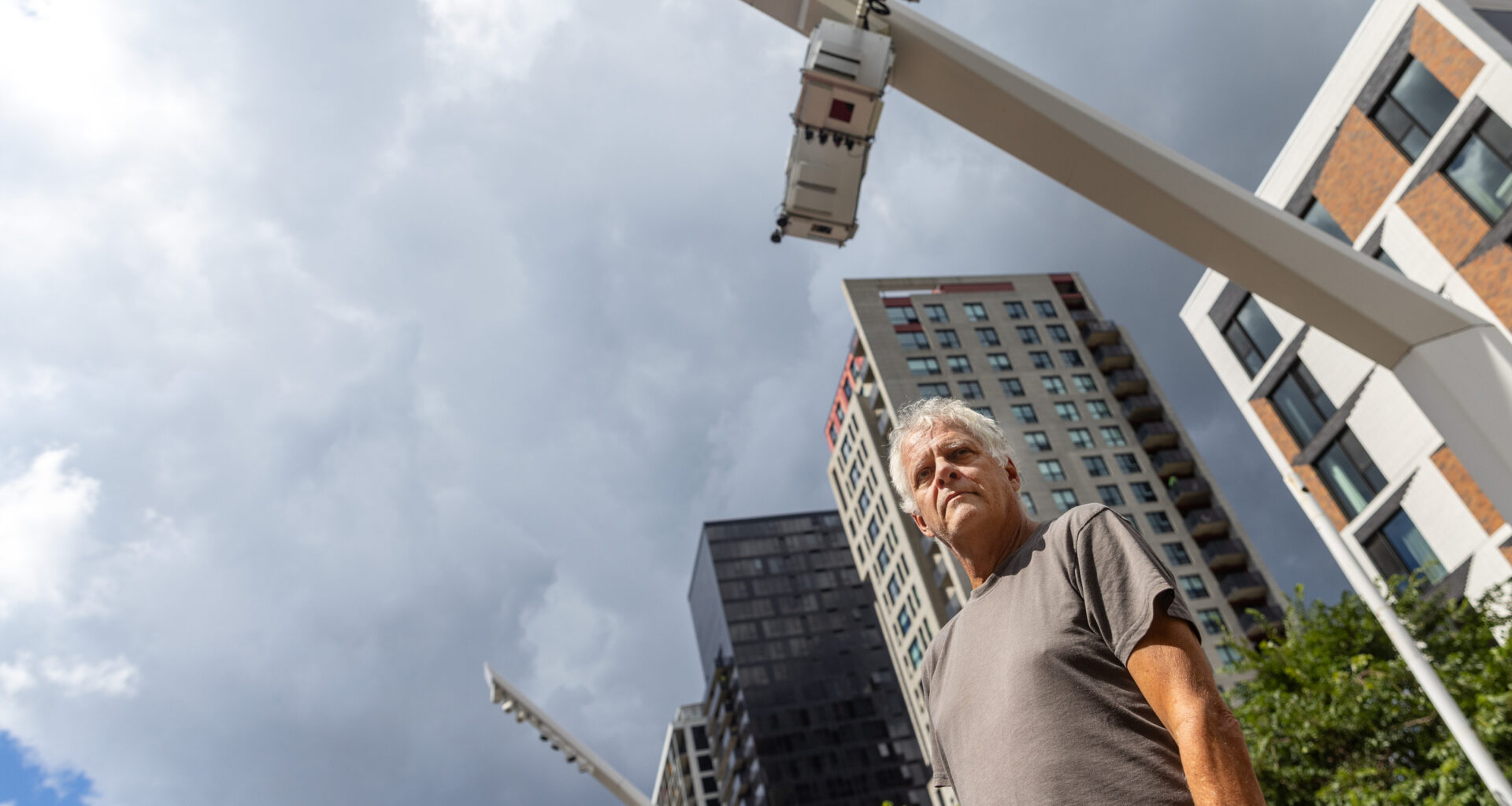 Alain Mongeau in an outside square, photographed from a low angle.