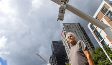 Alain Mongeau in an outside square, photographed from a low angle.