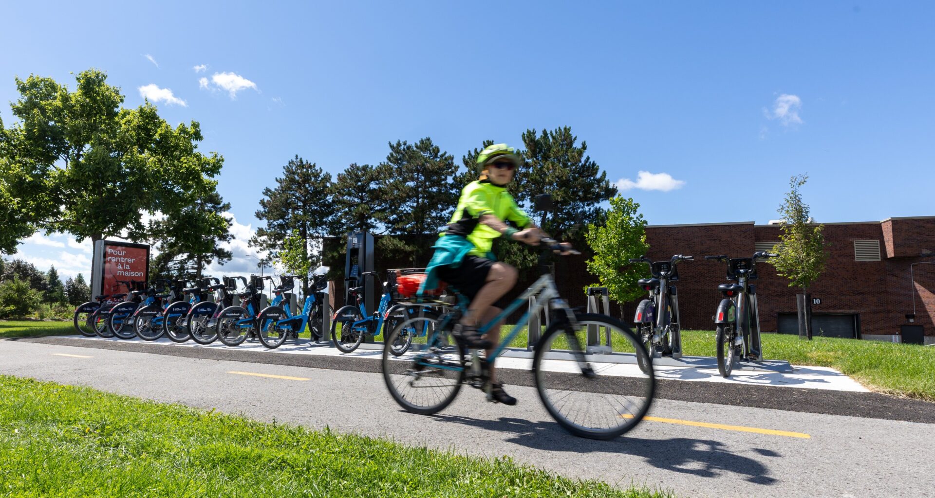 A cyclist rides past a Bixi bike station in front of city hall.