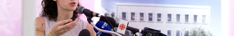 Woman addresses the media.