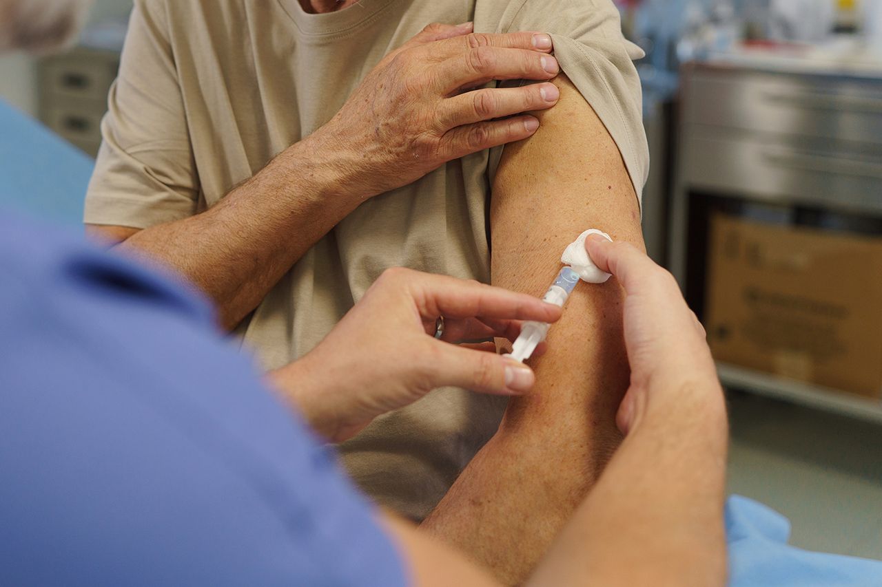 Stock image of a doctor administering a vaccine to a 50+ patientCredit: getty