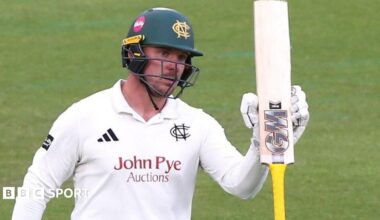 Liam Patterson-White raises his bat after reaching a half-century