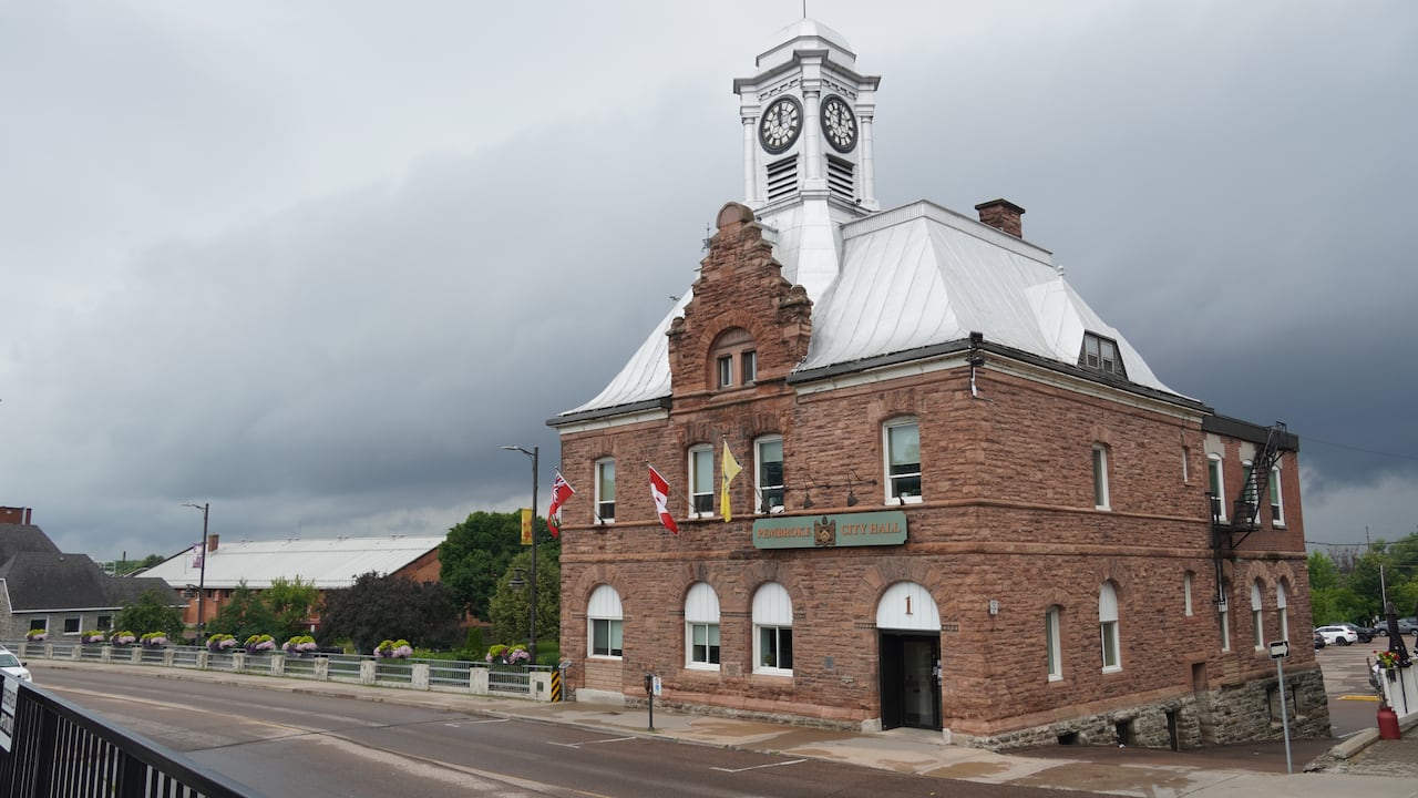 A street by a small city's city hall on a cloudy summer day.